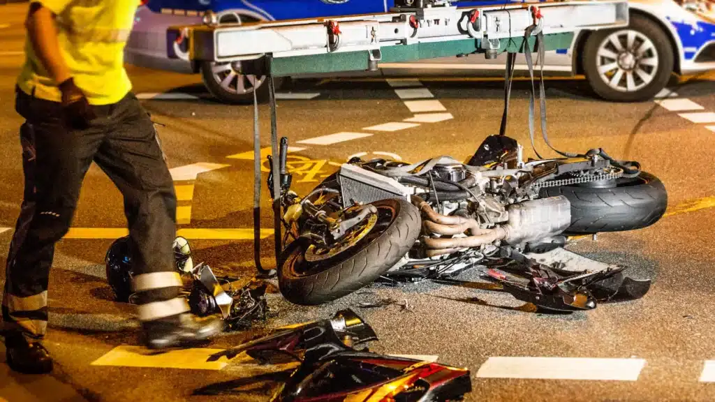 Motorcycle crash at intersection with debris scattered on the road.